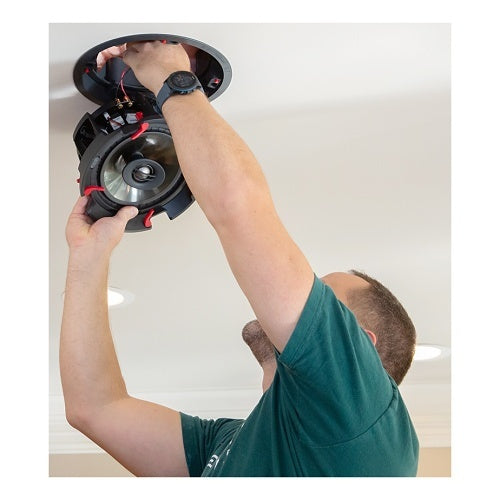 Installer fitting speaker into ceiling cradle